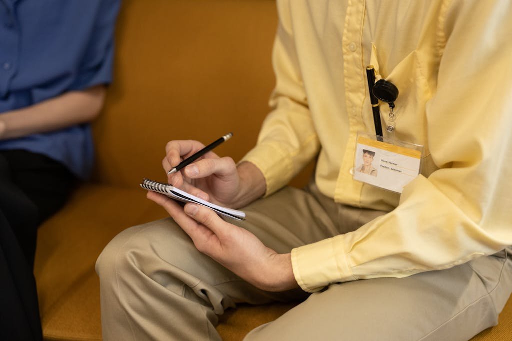 Close-up of a person taking notes on a notepad, capturing a professional setting.
